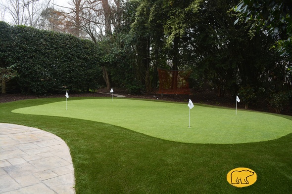 Augusta Synthetic grass golf green with 4 holes and flags in a landscaped backyard